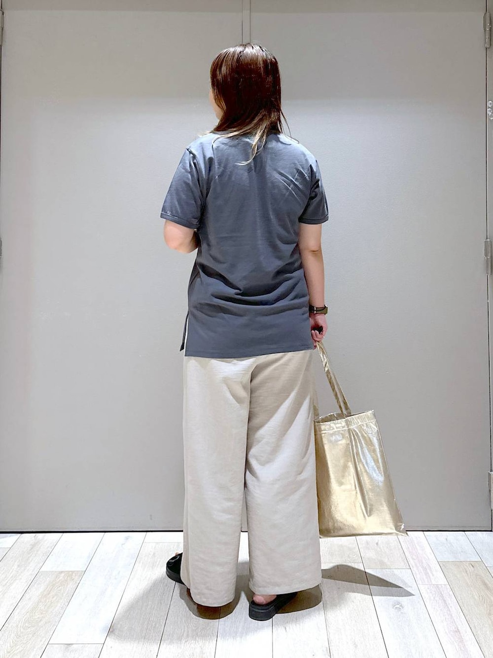 ベージュ系のその他パンツ、ブラック系のサンダル、ゴールド系のトートバッグを着用したレディースの夏コーディネートの3枚目の写真