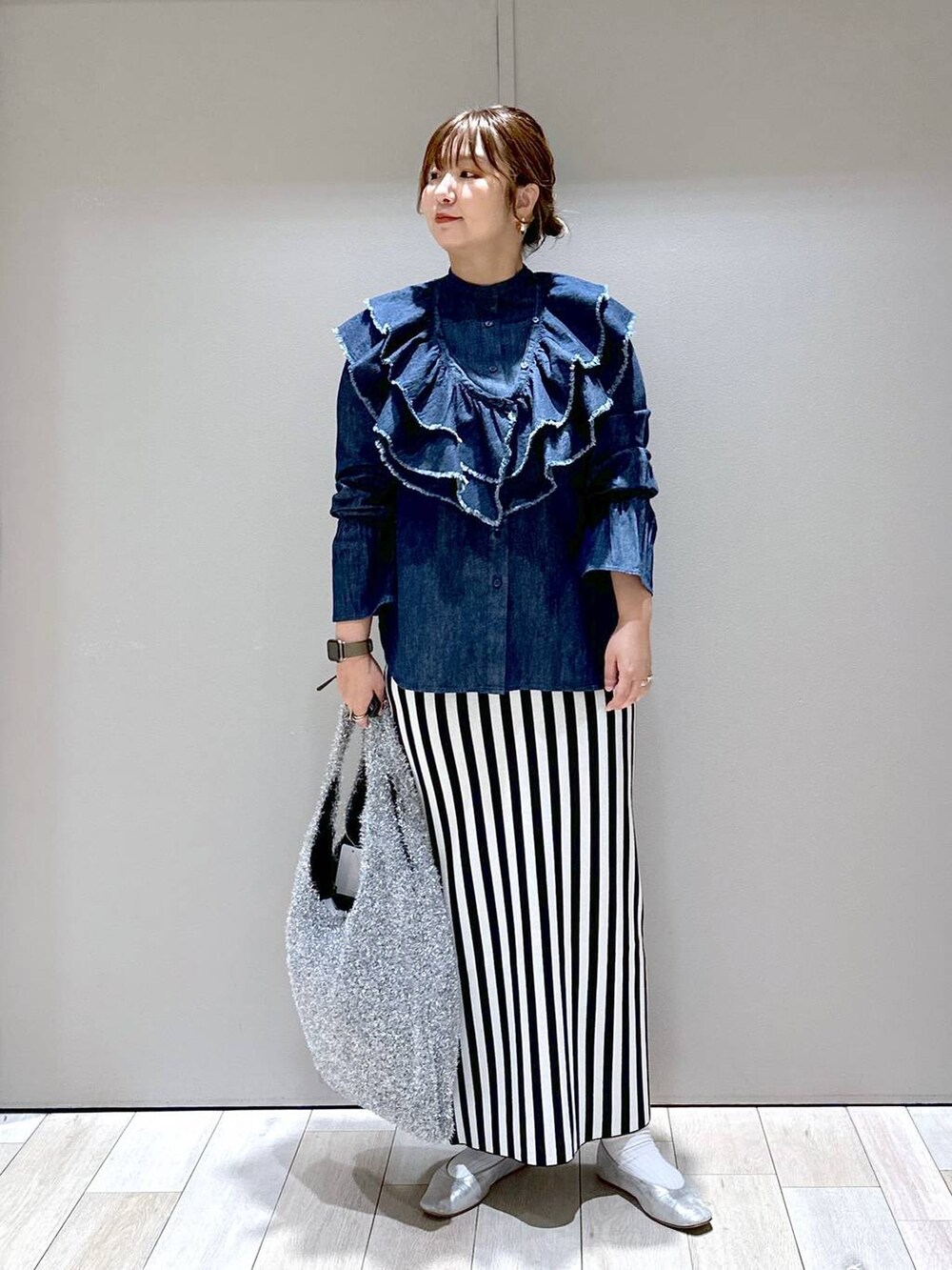 シルバー系のショルダーバッグ、シルバー系のパンプス、ブラック系のスカートを着用したレディースの秋コーディネートの5枚目の写真