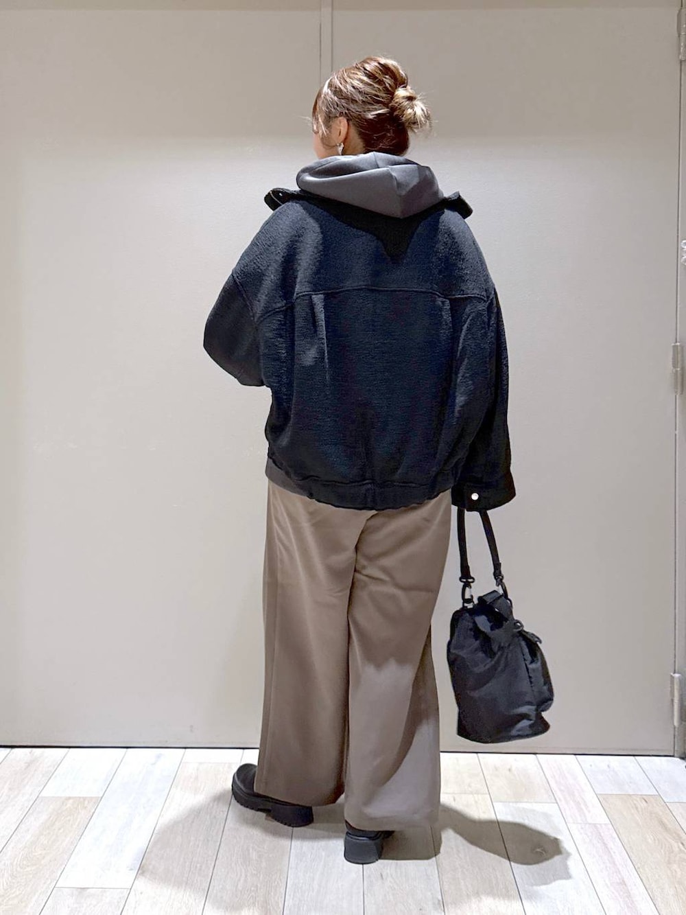 ブラック系のショルダーバッグ、ブラック系のブルゾン、ブラウン系のその他パンツを着用したレディースの冬コーディネートの3枚目の写真