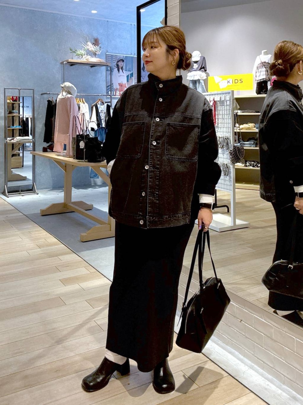 ブラック系のスカート、ブラック系のその他シューズ、ブラック系のボストンバッグを着用したレディースの秋コーディネートの3枚目の写真