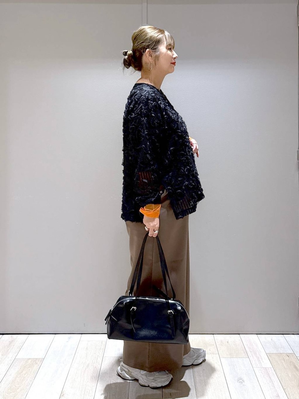 オレンジ系のTシャツ/カットソー、ブラック系のTシャツ/カットソー、ブラウン系のその他パンツを着用したレディースの秋コーディネートの2枚目の写真