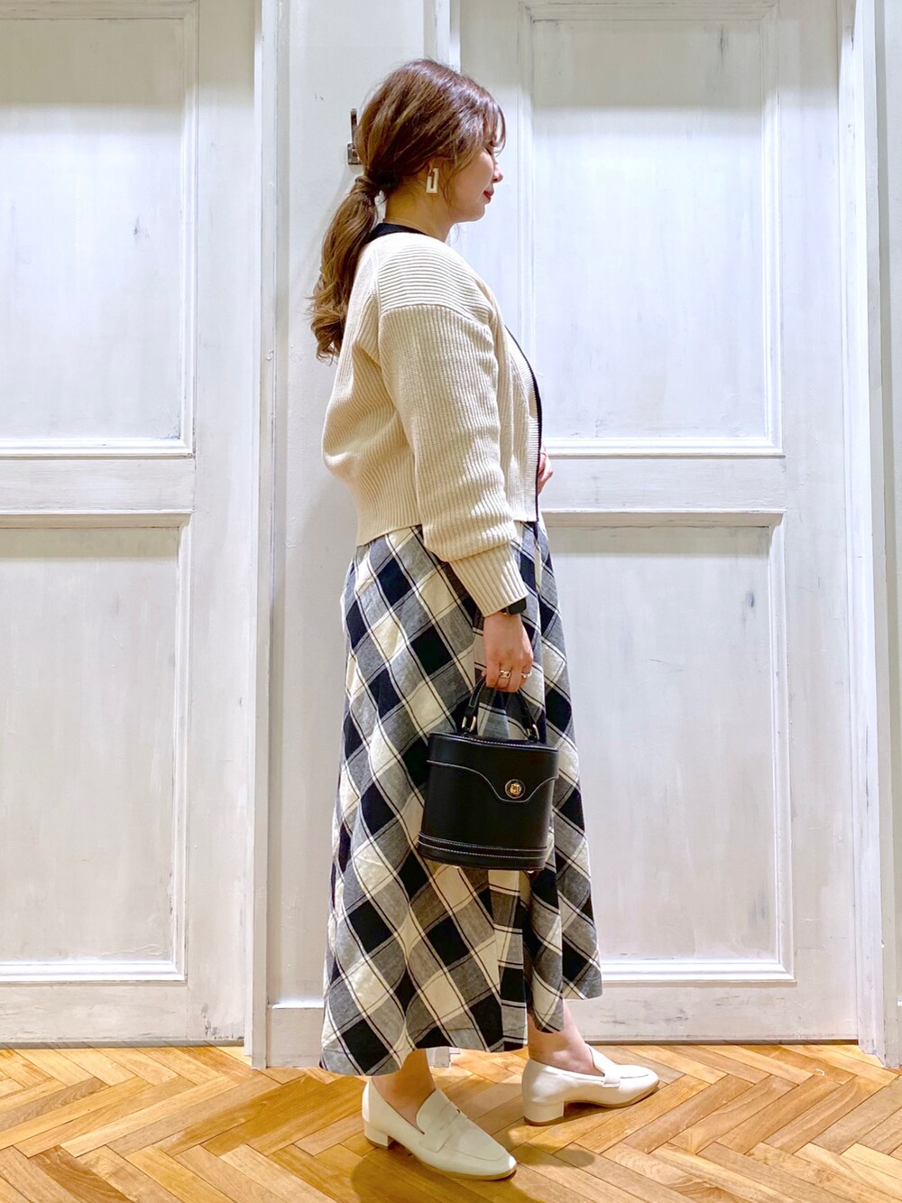 「春服みてみて、カーディガン、春コーデ、ローファー、春ニット、大人カジュアル、チェック柄、ロングワンピース、バニティバッグ、プレッピー、スクエアトゥ、andemiu、休日コーデ、新作、きれいめカジュアル」｜「Andemiuのステッチバニティバッグ274306（ショルダーバッグ、ブラック系）」を使った、たかみなさん（レディース・166cm）の春コーディネートの3枚目の写真