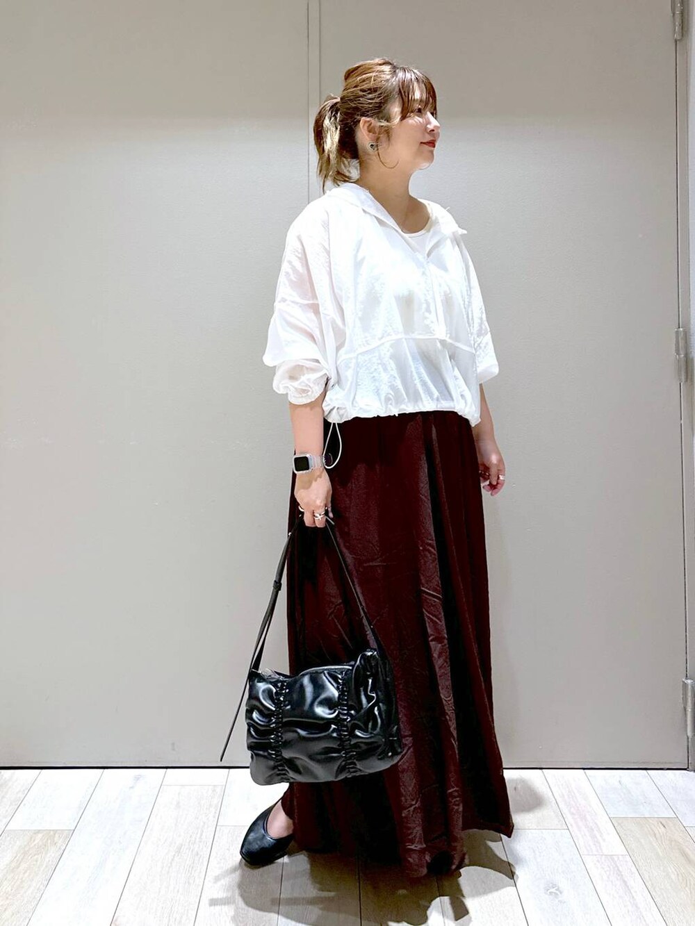 ブラック系のショルダーバッグ、ブラック系のパンプス、ブラウン系のスカートを着用したレディースの秋コーディネートの4枚目の写真