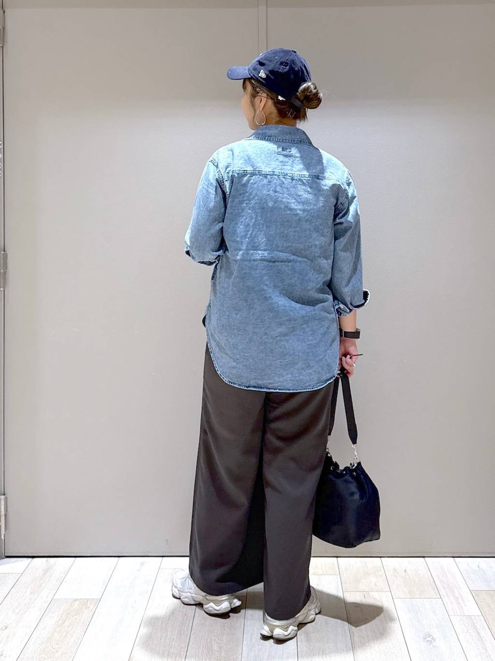 ブラック系のショルダーバッグ、ブルー系のシャツ/ブラウス、ブルー系のキャップを着用したレディースの秋コーディネートの3枚目の写真