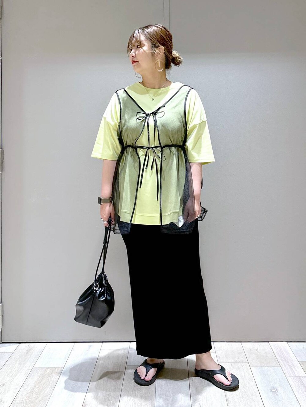 ブラック系のショルダーバッグ、ブラック系のベスト、ブラック系のサンダルを着用したレディースの春コーディネートの5枚目の写真