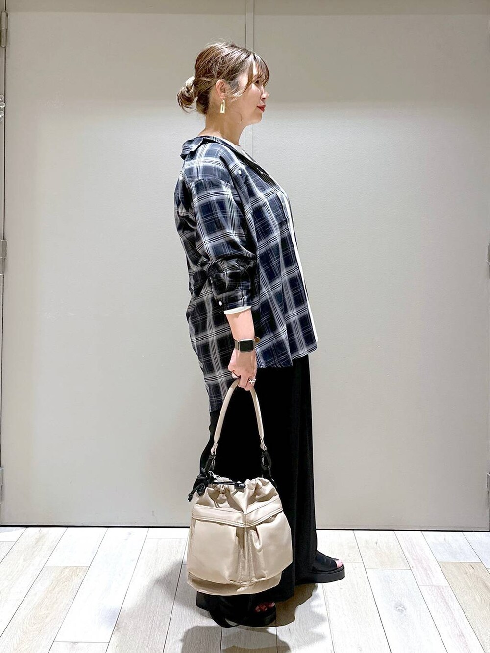 ホワイト系のTシャツ/カットソー、ブラック系のその他パンツ、ベージュ系のショルダーバッグを着用したレディースの春コーディネートの2枚目の写真