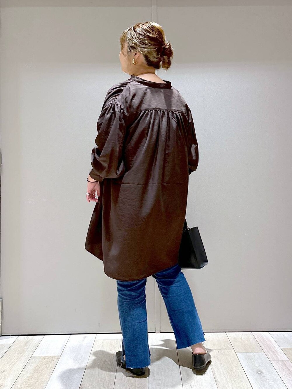 ブラック系のパンプス、ブラウン系のチュニック、ブラック系のショルダーバッグを着用したレディースの秋コーディネートの3枚目の写真