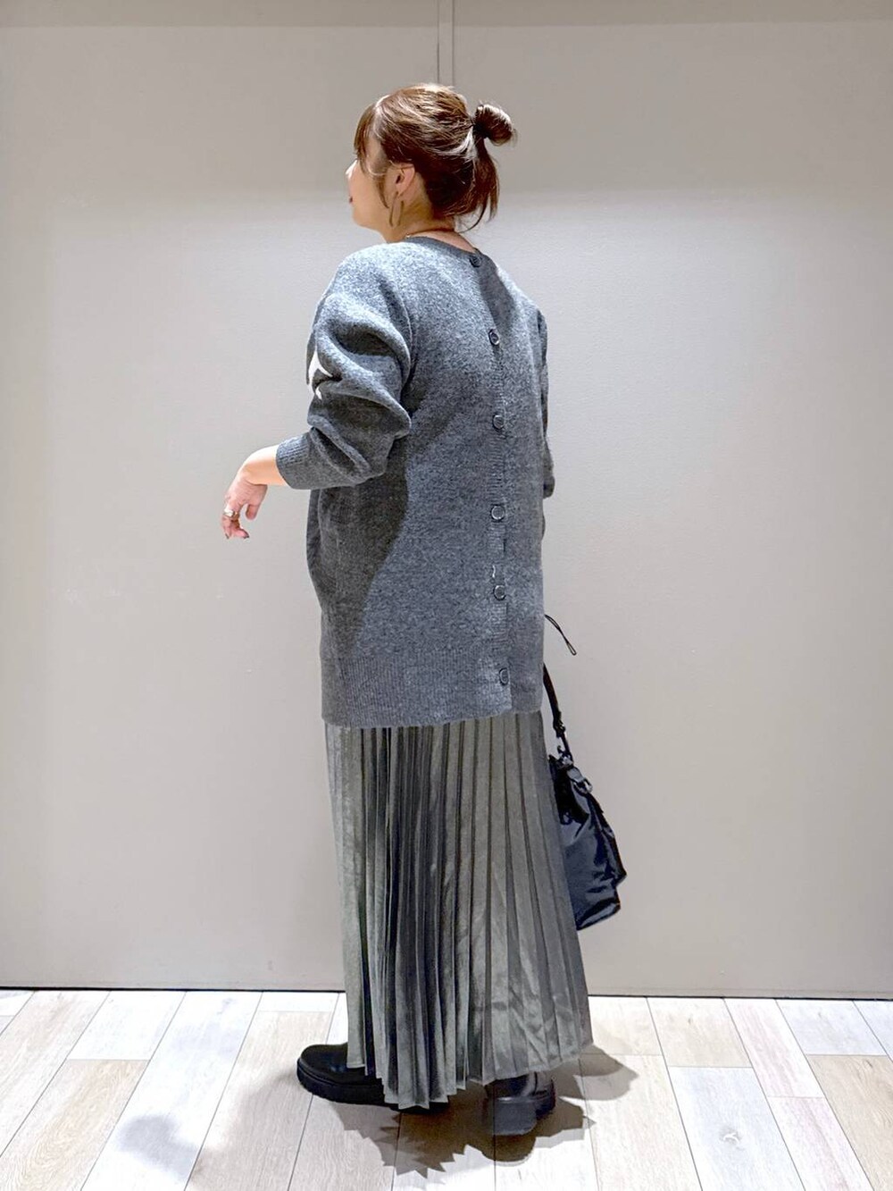 ブラック系のショルダーバッグ、ブラック系のブーツ、グレー系のスカートを着用したレディースの冬コーディネートの4枚目の写真