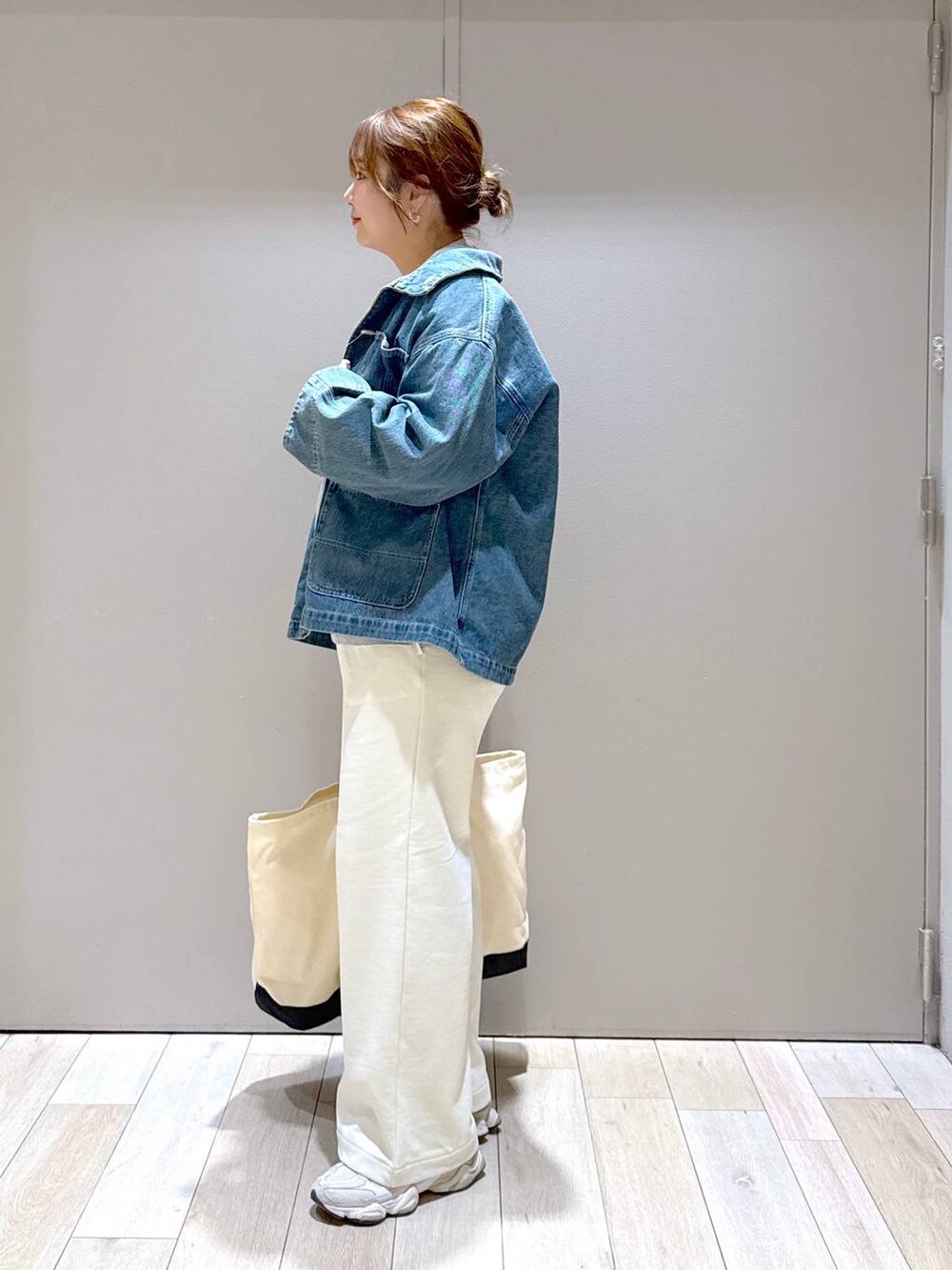 グレー系のTシャツ/カットソー、ホワイト系のトートバッグ、ブルー系のデニムジャケットを着用したレディースの冬コーディネートの4枚目の写真