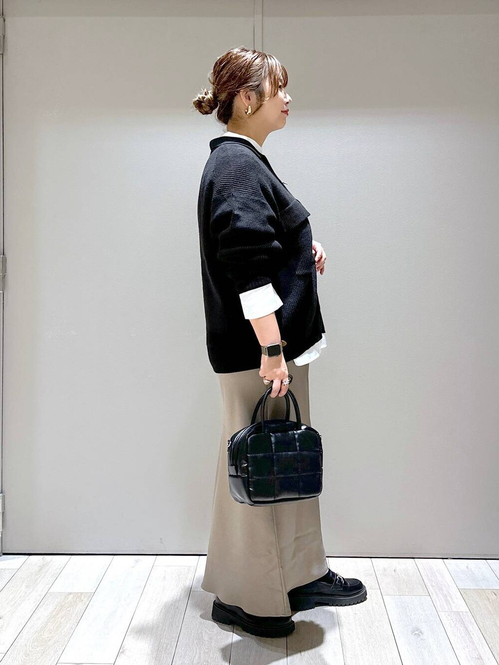 ブラック系のローファー、ブラック系のカーディガン/ボレロ、ブラウン系のスカートを着用したレディースの秋コーディネートの2枚目の写真