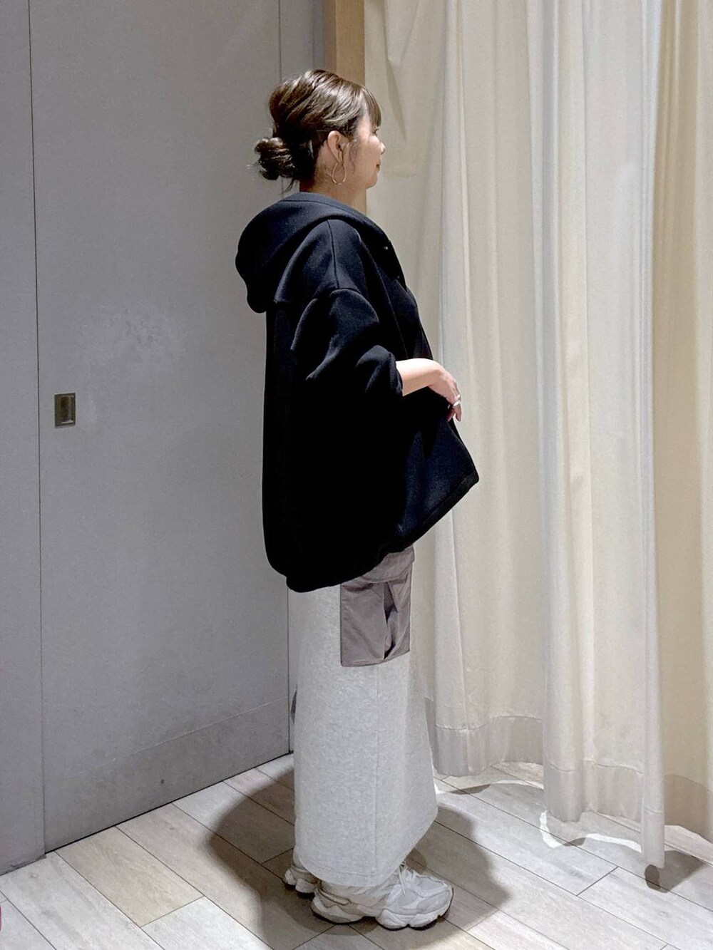 ブラック系のブルゾン、グレー系のスカート、シルバー系のショルダーバッグを着用したレディースの秋コーディネートの2枚目の写真