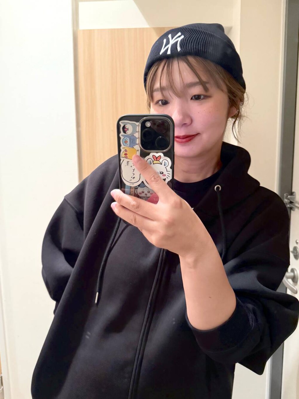 ブラック系のパーカーを着用したレディースの秋コーディネートの2枚目の写真