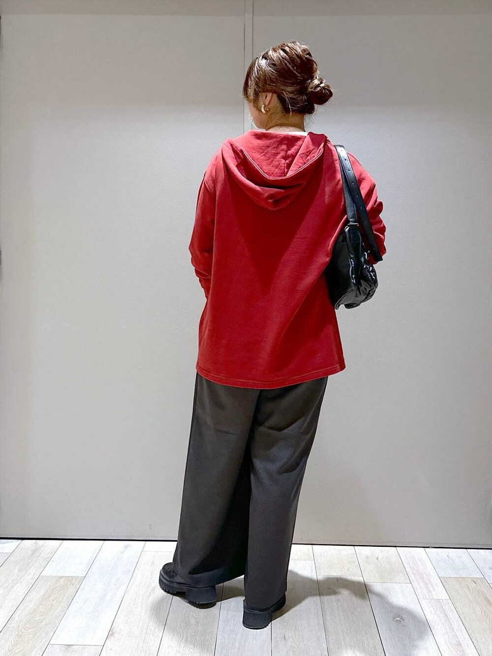 ブラック系のショルダーバッグ、レッド系のチュニック、グレー系のその他パンツを着用したレディースの秋コーディネートの3枚目の写真