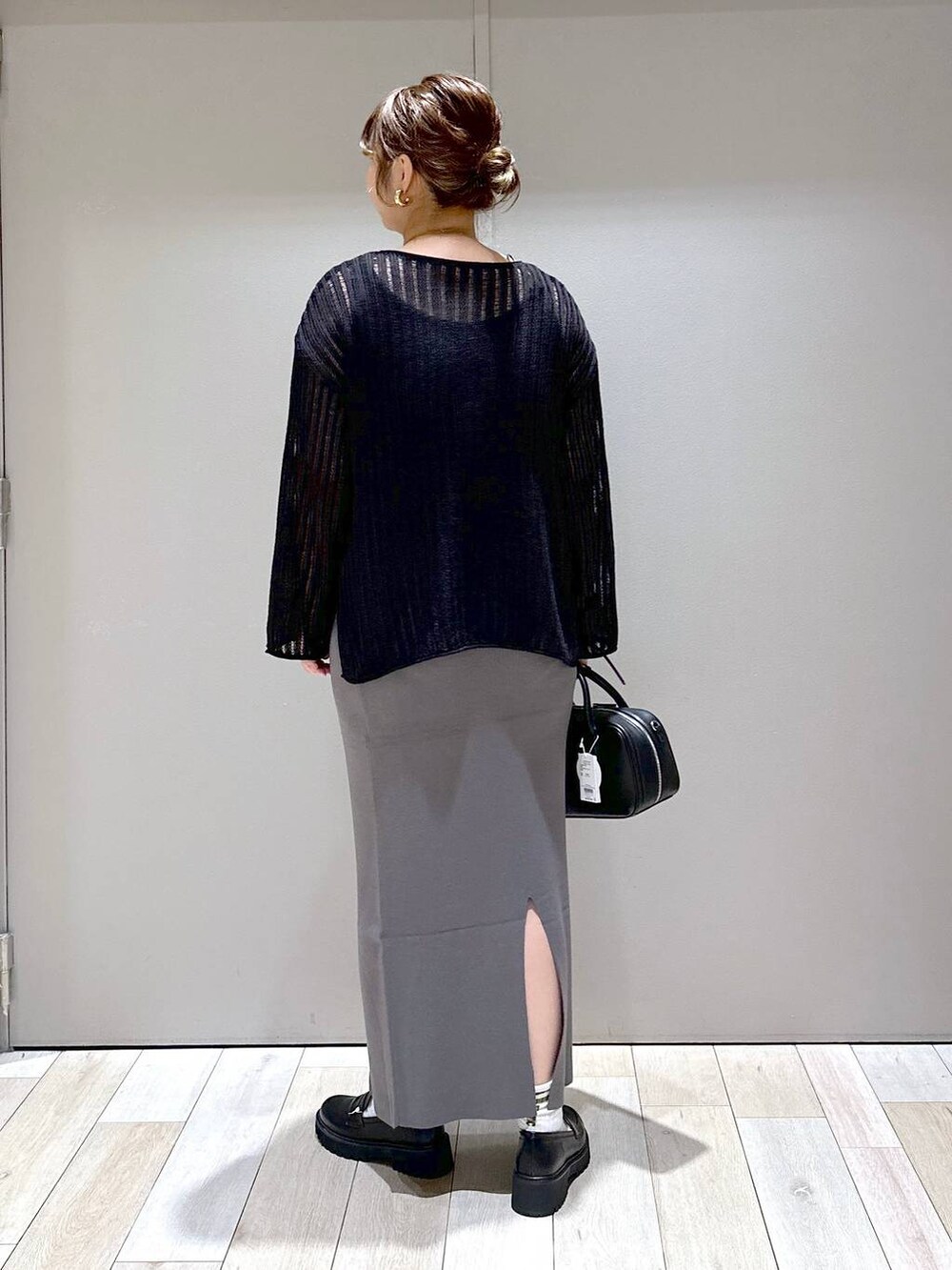 ブラック系のニット/セーター、ブラック系のボストンバッグ、ブラック系のローファーを着用したレディースの秋コーディネートの3枚目の写真