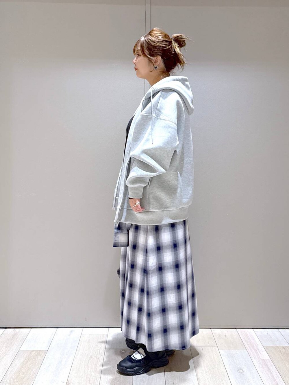 ブラック系のTシャツ/カットソー、オレンジ系のTシャツ/カットソー、グレー系のパーカーを着用したレディースの冬コーディネートの4枚目の写真