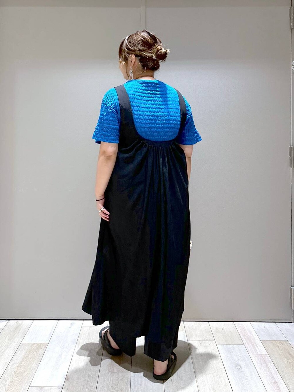 ホワイト系のかごバッグ、ブラック系のサンダル、ブラック系のスラックスを着用したレディースの夏コーディネートの3枚目の写真