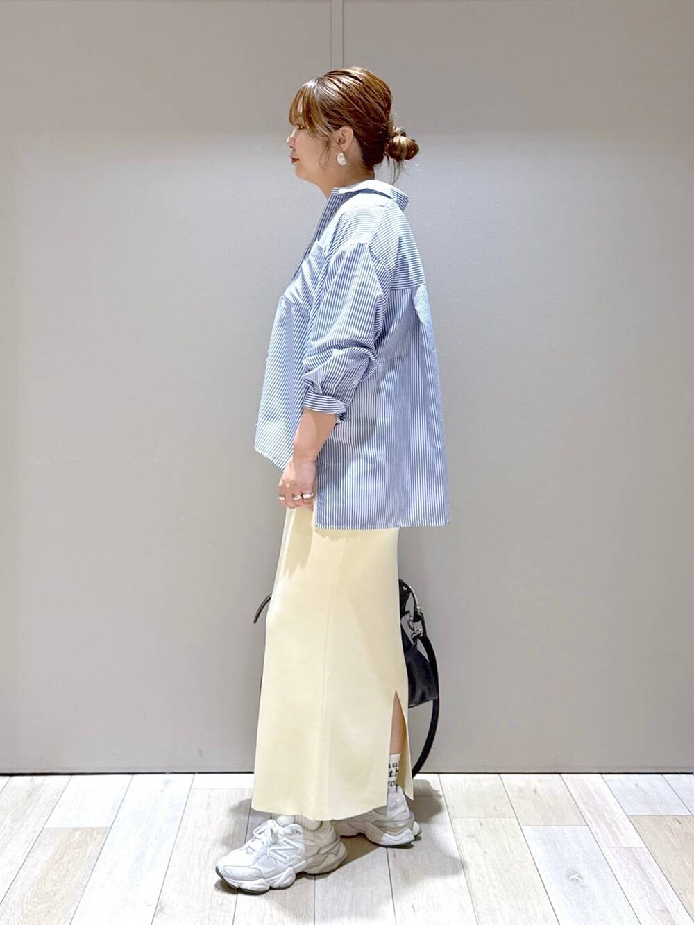 ホワイト系のスカート、ブラック系のトートバッグ、ブルー系のシャツ/ブラウスを着用したレディースの春コーディネートの4枚目の写真