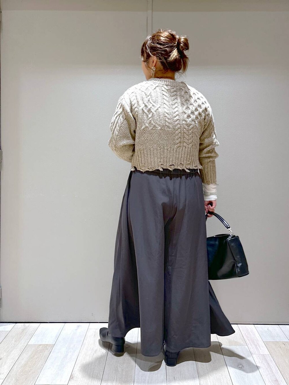 グレー系のその他パンツ、ホワイト系のTシャツ/カットソー、ブラック系のブーツを着用したレディースの秋コーディネートの3枚目の写真