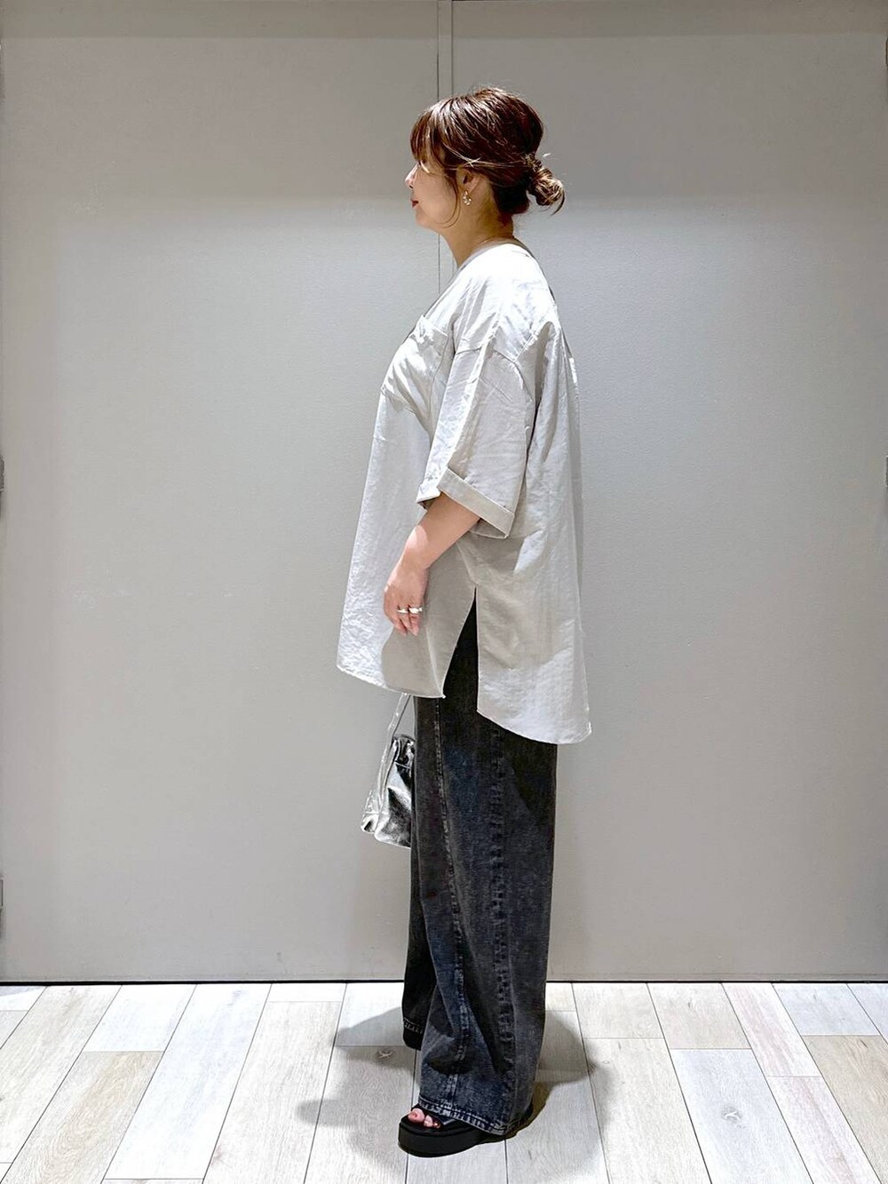 シルバー系のショルダーバッグ、グレー系のワンピース、ブラック系のサンダルを着用したレディースの夏コーディネートの4枚目の写真