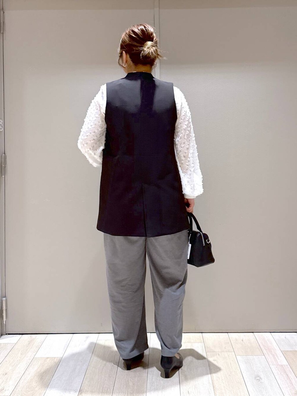 ホワイト系のシャツ/ブラウス、ブラック系のスーツベスト、グレー系のその他パンツを着用したレディースの冬コーディネートの3枚目の写真