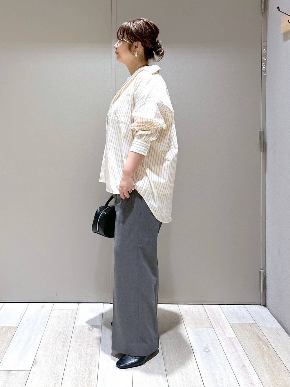 ブラック系のボストンバッグ、ブラック系のパンプス、ホワイト系のTシャツ/カットソーを着用したレディースの秋コーディネートの2枚目の写真