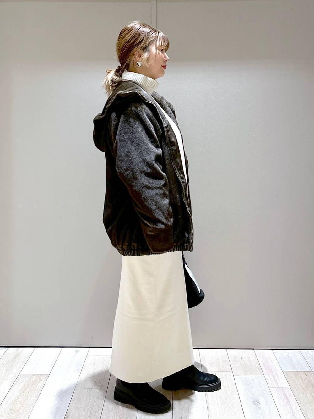 ホワイト系のニット/セーター、ホワイト系のスカート、グリーン系のブルゾンを着用したレディースの冬コーディネートの2枚目の写真