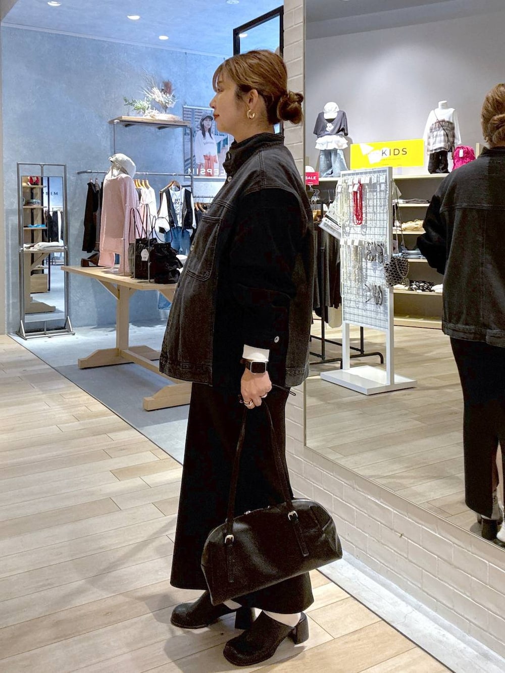 ブラック系のスカート、ブラック系のその他シューズ、ブラック系のボストンバッグを着用したレディースの秋コーディネートの2枚目の写真