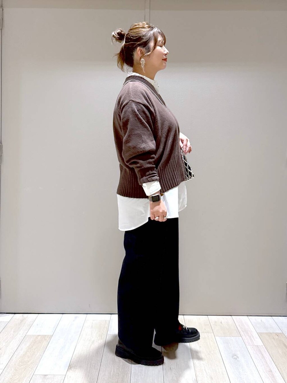 ブラウン系のニット/セーター、ブラック系のローファー、ホワイト系のシャツ/ブラウスを着用したレディースの冬コーディネートの2枚目の写真