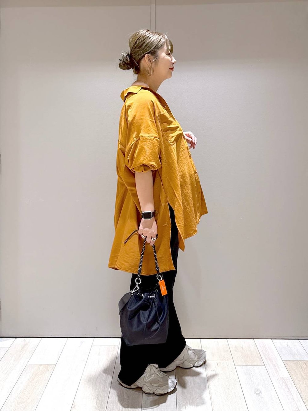 オレンジ系のシャツ/ブラウス、ブラック系のショルダーバッグ、ブラック系のその他パンツを着用したレディースの秋コーディネートの2枚目の写真