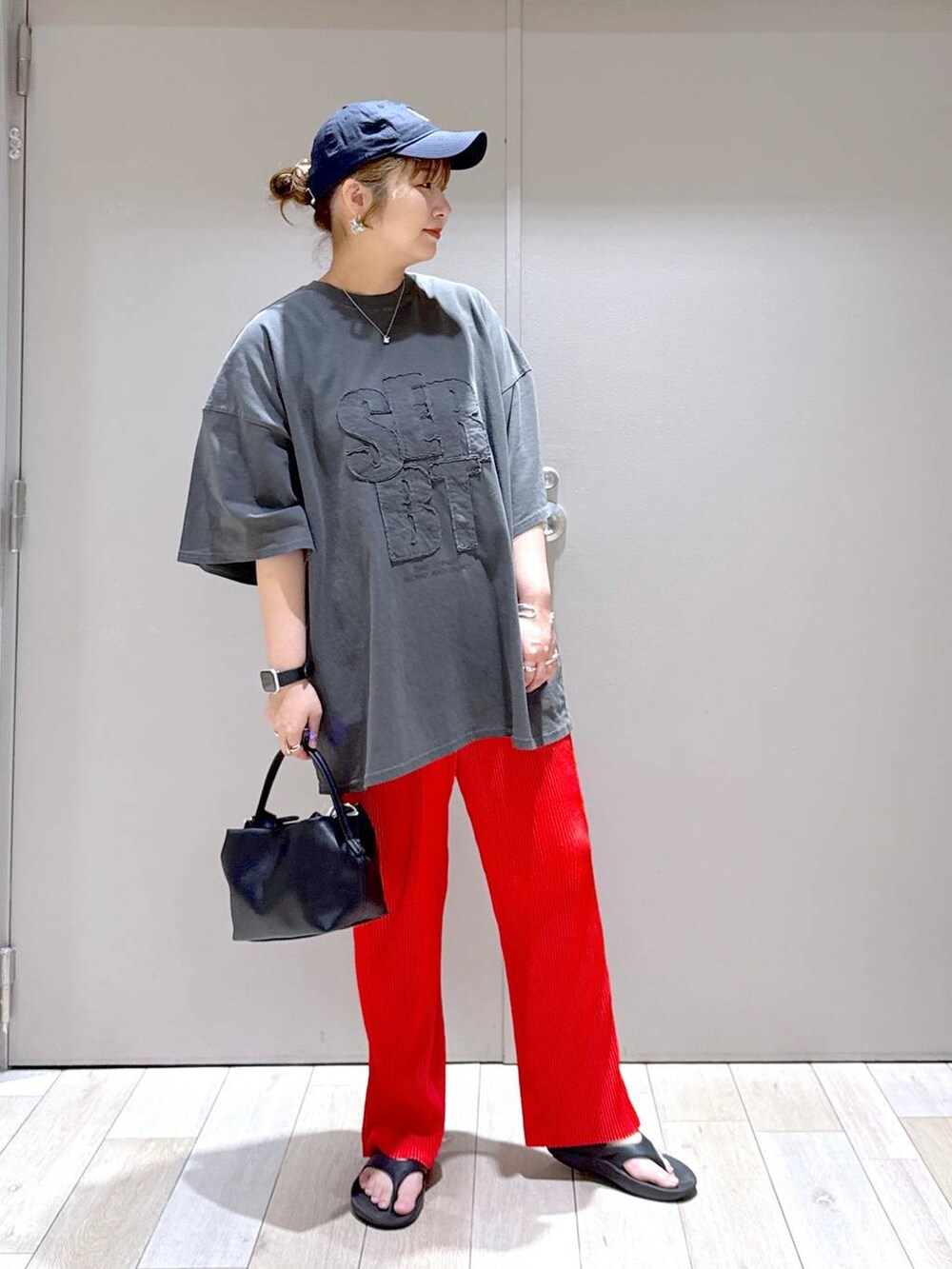 グレー系のTシャツ/カットソー、ブラック系のショルダーバッグ、ブラック系のサンダルを着用したレディースの春コーディネートの5枚目の写真