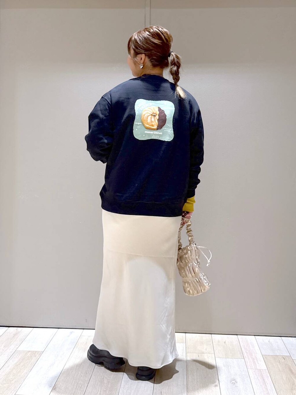 ブラック系のニット/セーター、ホワイト系のスカート、ブラック系のブーツを着用したレディースの冬コーディネートの3枚目の写真