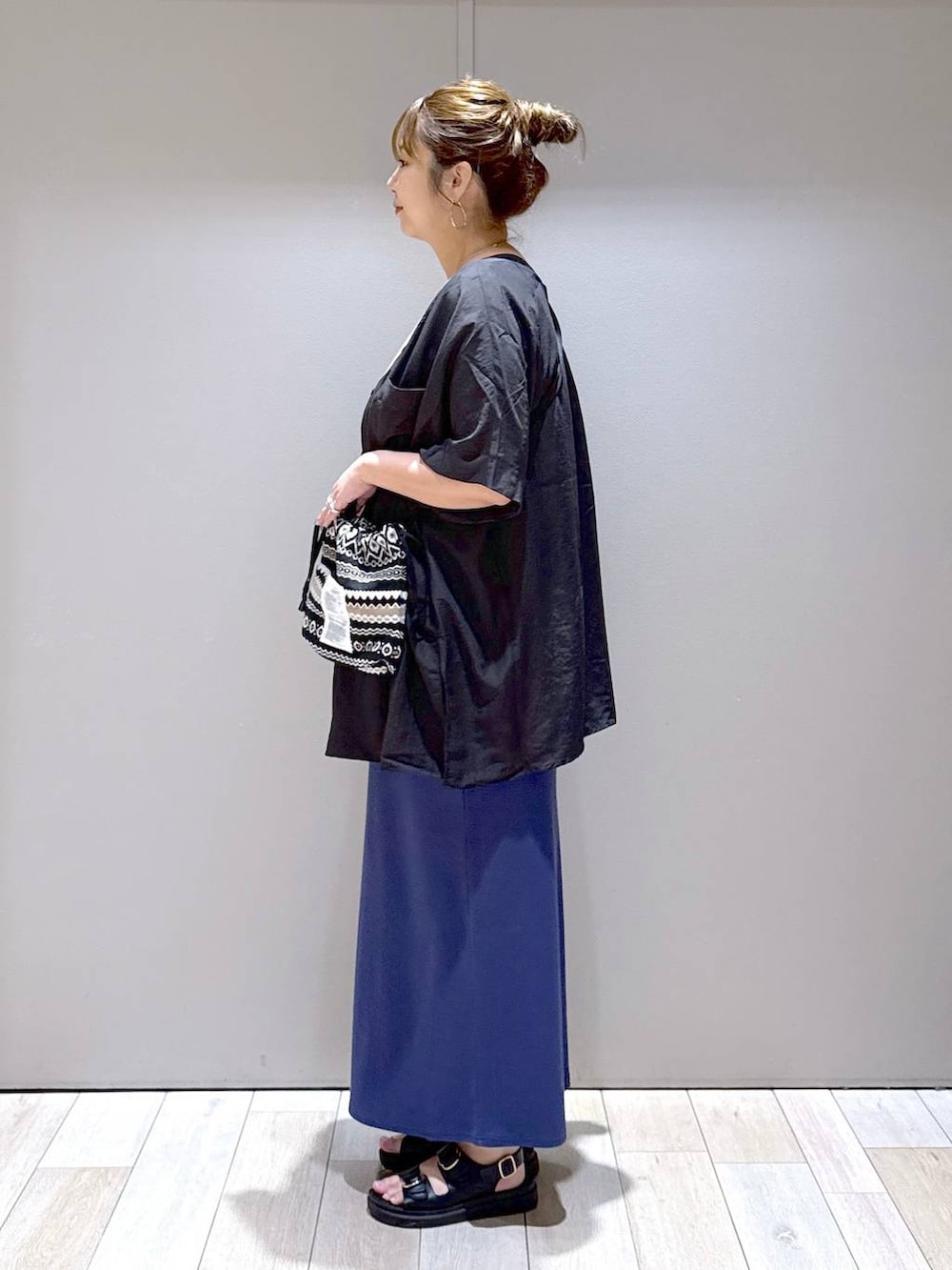 ブルー系のスカート、ブラック系のサンダル、ホワイト系のTシャツ/カットソーを着用したレディースの夏コーディネートの4枚目の写真