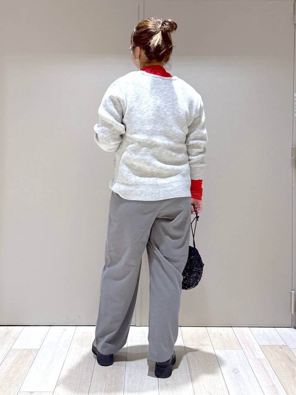 ブラック系のブーツ、ブラック系のショルダーバッグ、レッド系のTシャツ/カットソーを着用したレディースの冬コーディネートの3枚目の写真