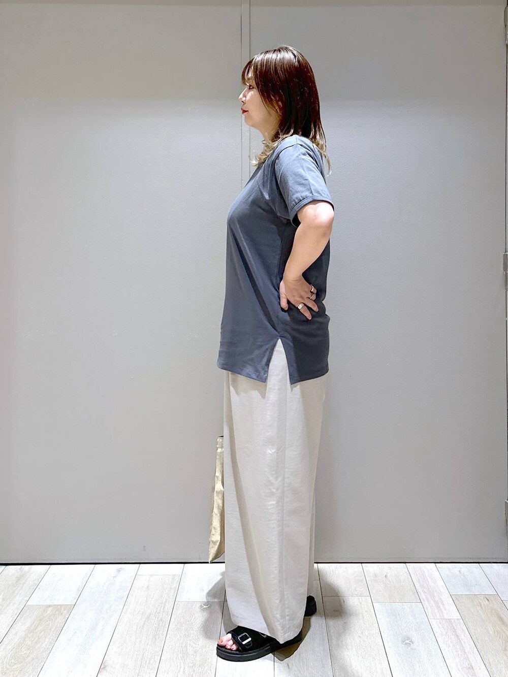 ベージュ系のその他パンツ、ブラック系のサンダル、ゴールド系のトートバッグを着用したレディースの夏コーディネートの2枚目の写真