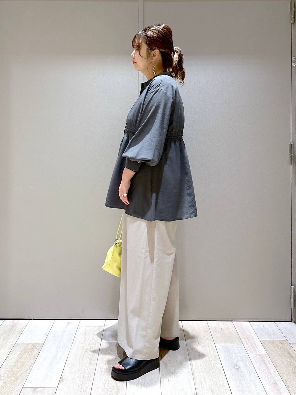 グレー系のシャツ/ブラウス、イエロー系のショルダーバッグ、ブラック系のサンダルを着用したレディースの春コーディネートの4枚目の写真
