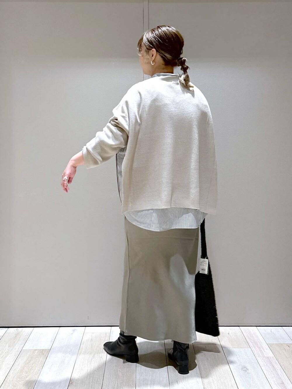 ベージュ系のニット/セーター、ブラック系のシャツ/ブラウス、ブラック系のブーツを着用したレディースの秋コーディネートの3枚目の写真