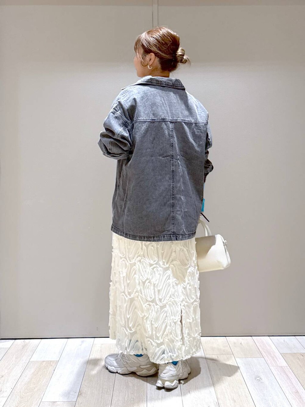 ホワイト系のボストンバッグ、ブラック系のシャツ/ブラウス、ブラック系のニット/セーターを着用したレディースの冬コーディネートの3枚目の写真