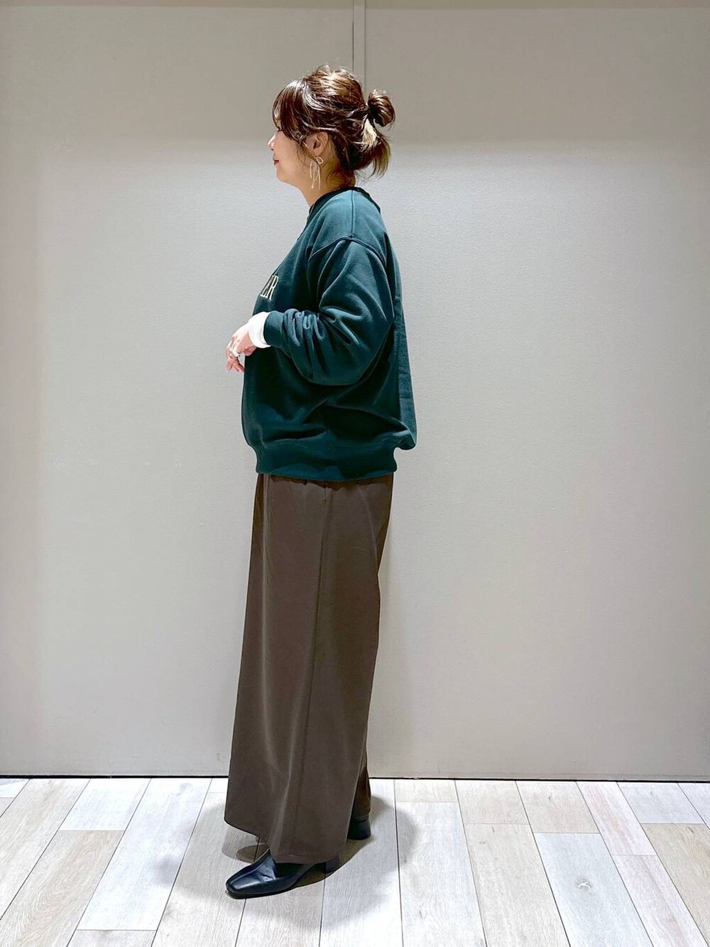 ブラック系のショルダーバッグ、ホワイト系のTシャツ/カットソー、ブラック系のブーツを着用したレディースの秋コーディネートの4枚目の写真