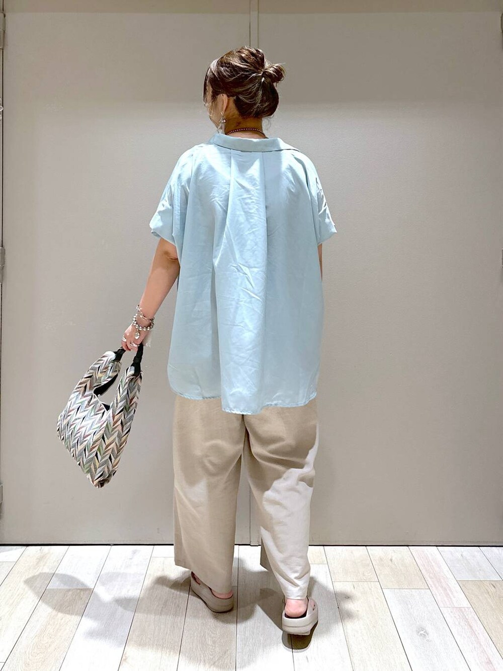 ベージュ系のその他パンツ、ホワイト系のハンドバッグ、ベージュ系のサンダルを着用したレディースの春コーディネートの3枚目の写真
