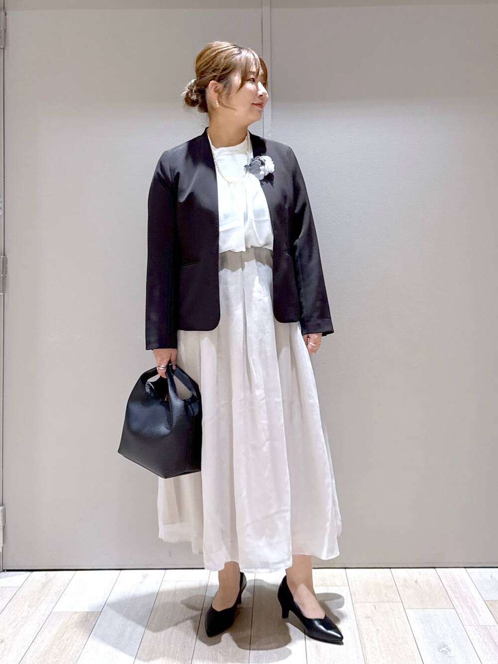 ベージュ系のスカート、ホワイト系のシャツ/ブラウス、ブラック系のスーツジャケットを着用したレディースの冬コーディネートの5枚目の写真