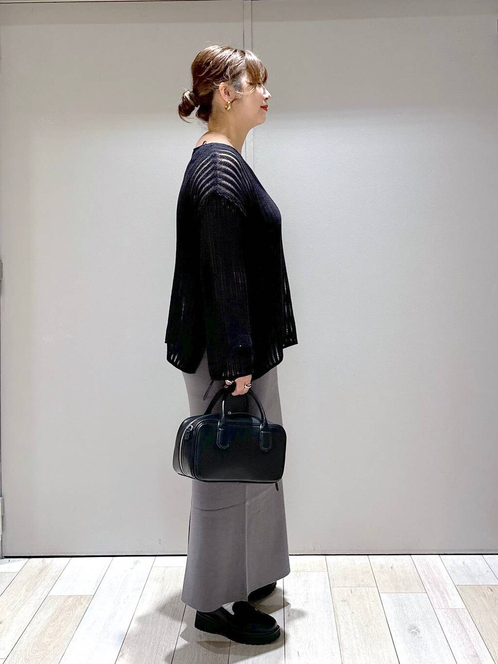 ブラック系のニット/セーター、ブラック系のボストンバッグ、ブラック系のローファーを着用したレディースの秋コーディネートの2枚目の写真