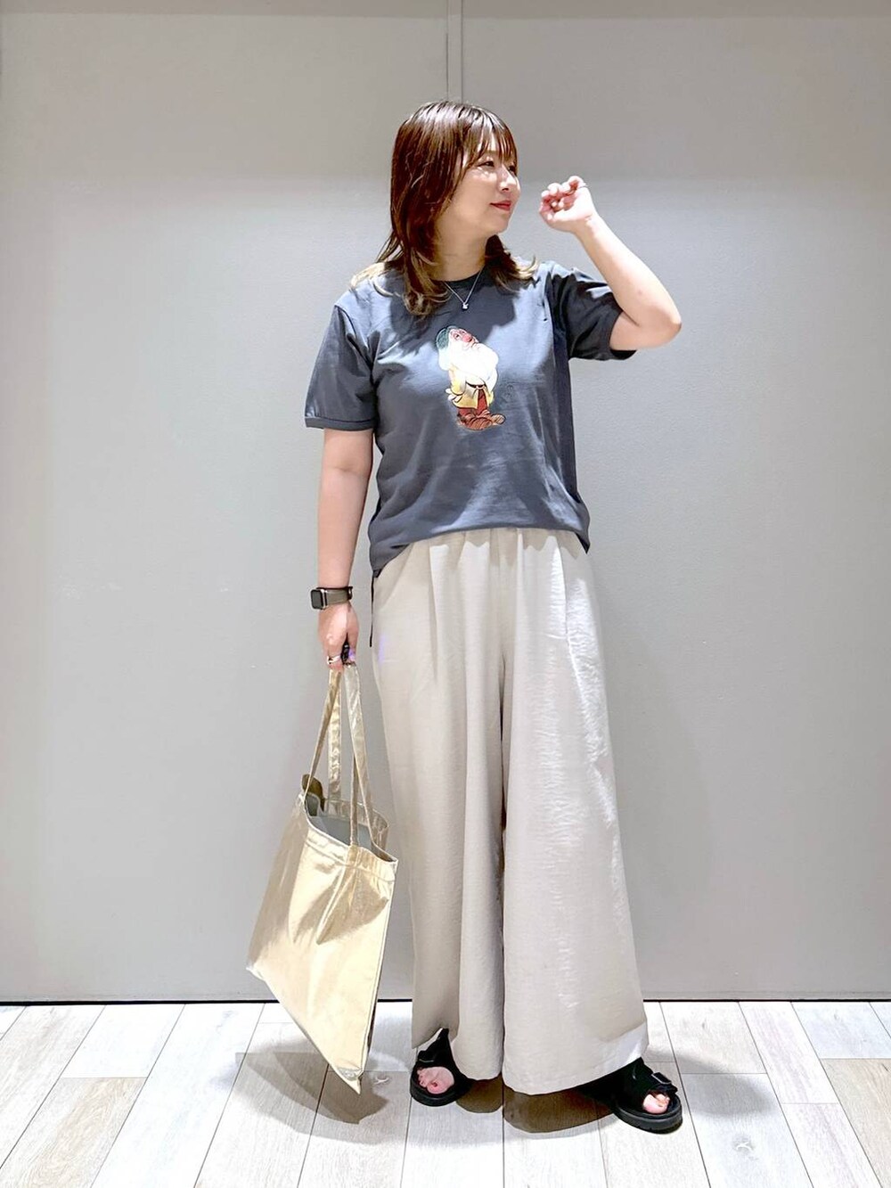 ベージュ系のその他パンツ、ブラック系のサンダル、ゴールド系のトートバッグを着用したレディースの夏コーディネートの4枚目の写真