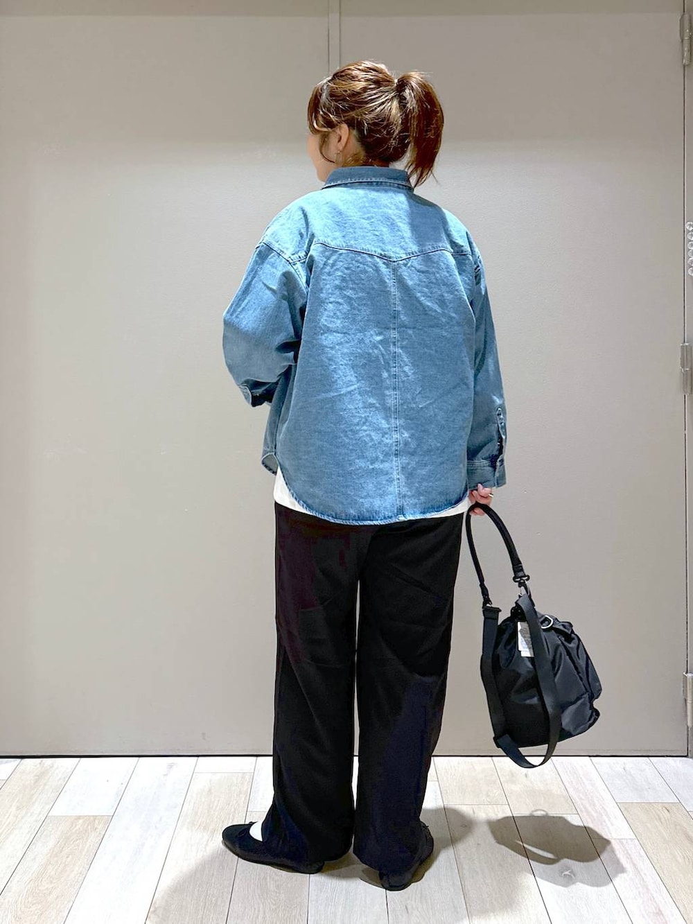 ブラック系のショルダーバッグ、ブラック系のバレエシューズ、ブルー系のシャツ/ブラウスを着用したレディースの秋コーディネートの3枚目の写真