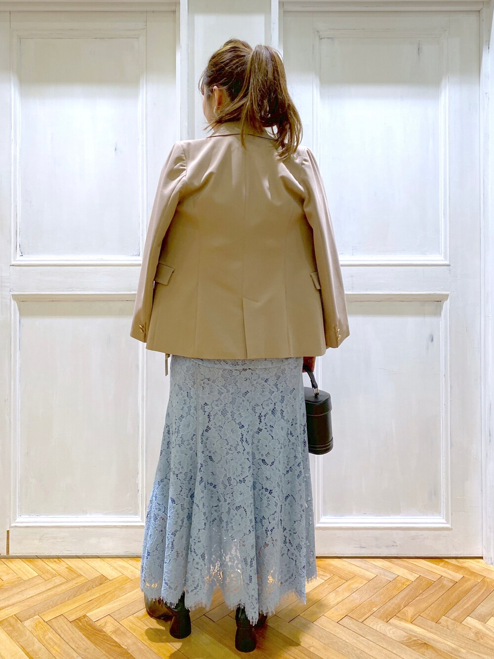 ブラック系のパンプス、ブラック系のショルダーバッグ、ブルー系のシャツ/ブラウスを着用したレディースの春コーディネートの4枚目の写真