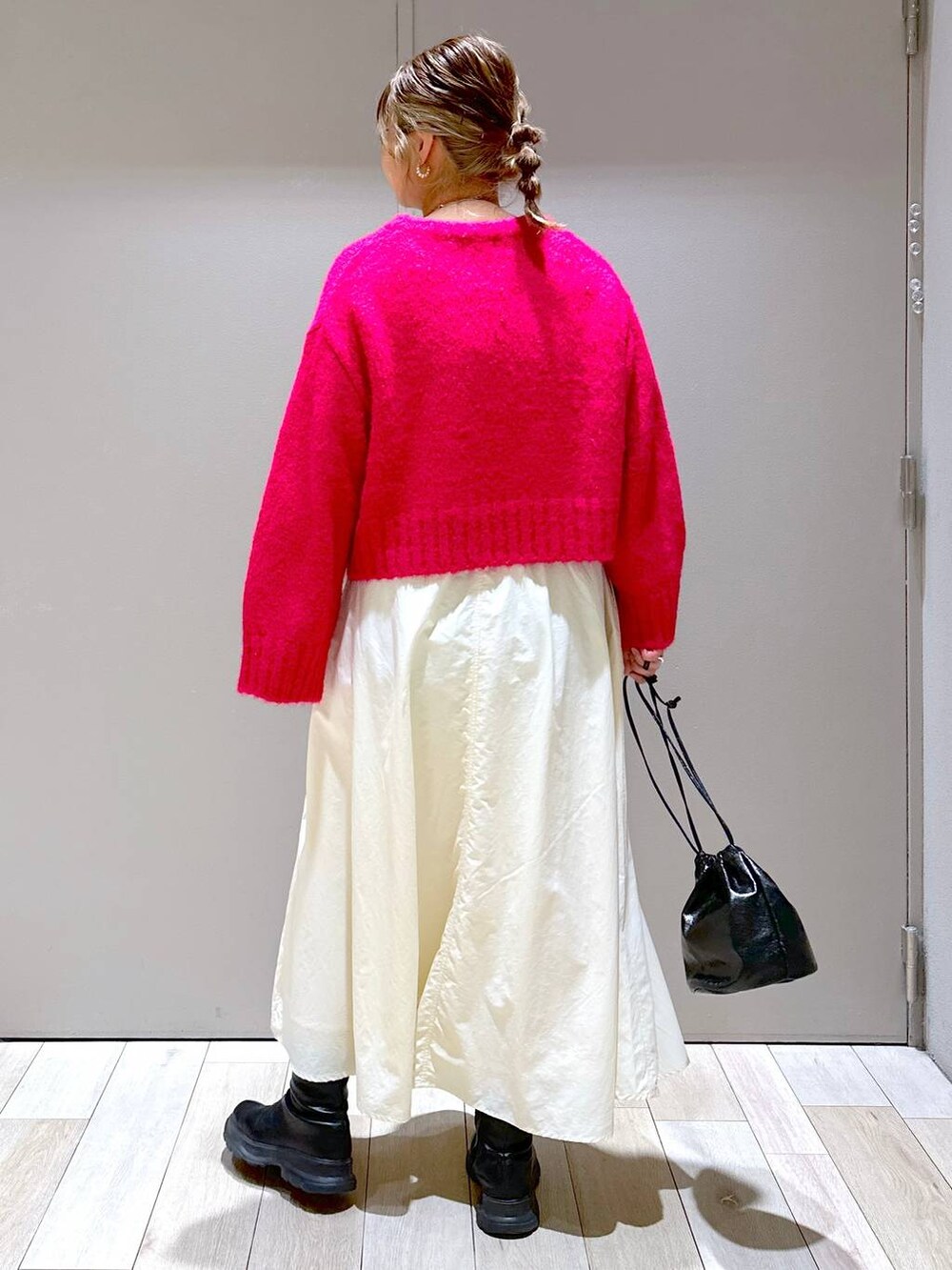 ブラック系のショルダーバッグ、ブラック系のブーツ、ホワイト系のスカートを着用したレディースの冬コーディネートの3枚目の写真