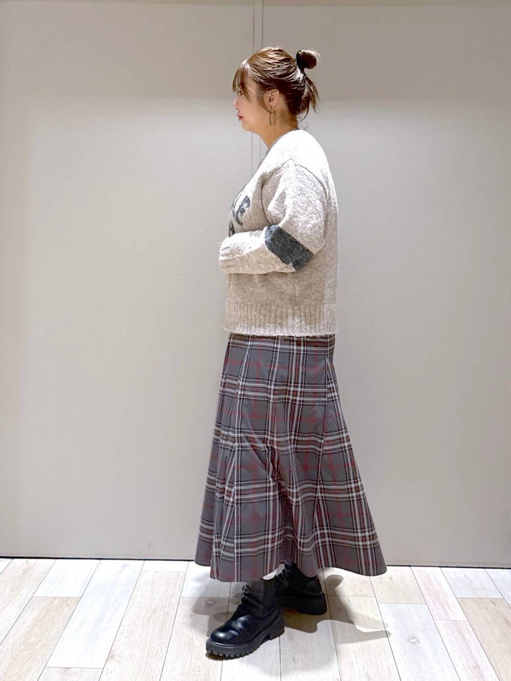 グレー系のスカート、ブラック系のブーツ、ブラック系のショルダーバッグを着用したレディースの冬コーディネートの4枚目の写真