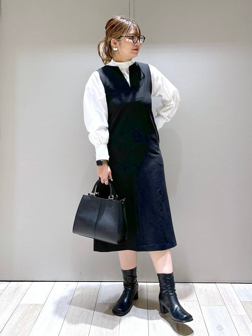 ブラウン系のノーカラーコート、ブラック系のブーツ、ホワイト系のシャツ/ブラウスを着用したレディースの冬コーディネートの2枚目の写真