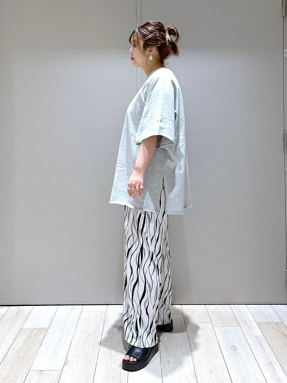 ブラック系のショルダーバッグ、グレー系のTシャツ/カットソー、ブラック系のサンダルを着用したレディースの春コーディネートの4枚目の写真