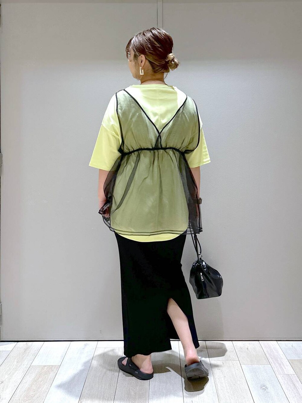 ブラック系のショルダーバッグ、ブラック系のベスト、ブラック系のサンダルを着用したレディースの春コーディネートの3枚目の写真