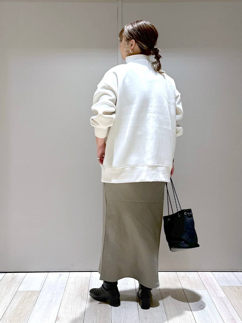 ホワイト系のTシャツ/カットソー、ブラック系のブーツ、グリーン系のスカートを着用したレディースの秋コーディネートの3枚目の写真